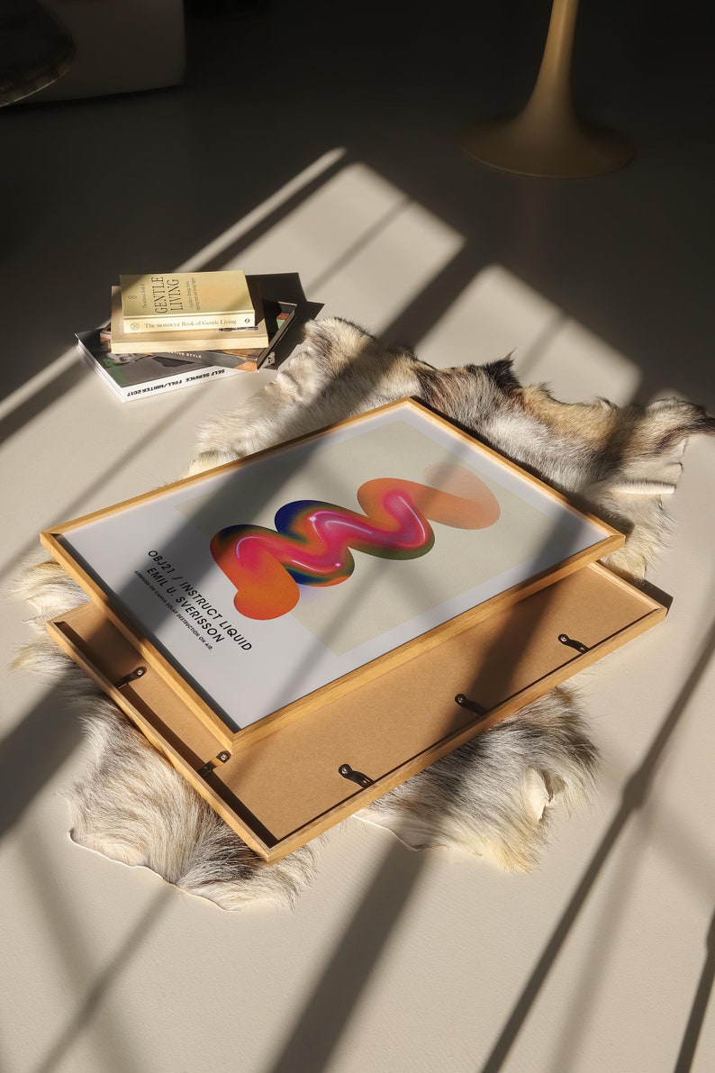 May include: A framed abstract art print with a colorful, swirling design in shades of orange, pink, blue, and green. The print is titled "082217 / INSTRUCT LIQUID FORM 1 VERSION" and is by Emil du Sv&eacute;risson.