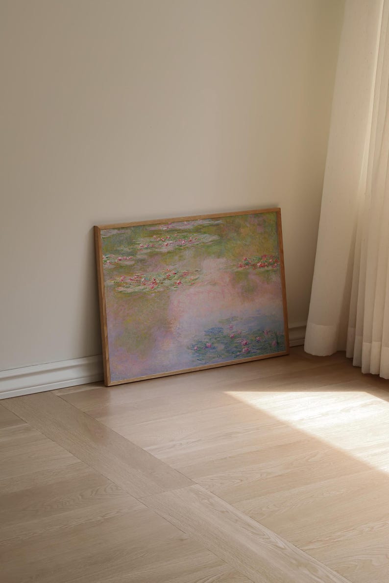 Puede incluir: Una impresi&oacute;n rectangular enmarcada que presenta una pintura de estilo impresionista de un estanque de nen&uacute;fares. La obra muestra tonos suaves de rosa, verde y azul, representando nen&uacute;fares flotantes y flores sobre una superficie de agua reflectante.