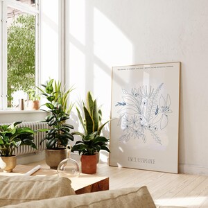 Op de afbeelding: Een witte poster met een blauwe lijntekening van bloemen en de tekst "WELCOME TO SUMMER AND 2017 SPRING IN THE BOTANICAL GARDEN UNCLASSIFIABLE". De poster leunt tegen een witte muur met een raam en potplanten op de achtergrond.