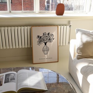 May include: A black and white line drawing of a bouquet of flowers in a vase. The drawing is on a white background with a wooden frame. The text "SUNDAY GALERIE" is printed below the drawing.
