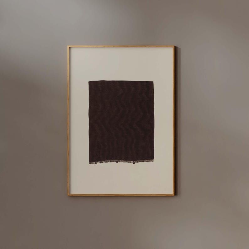 Puede incluir: Impresi&oacute;n art&iacute;stica abstracta enmarcada que presenta una forma rectangular texturizada de color marr&oacute;n oscuro con un patr&oacute;n en zigzag sobre un fondo crema. La obra de arte est&aacute; encerrada en un marco dorado.