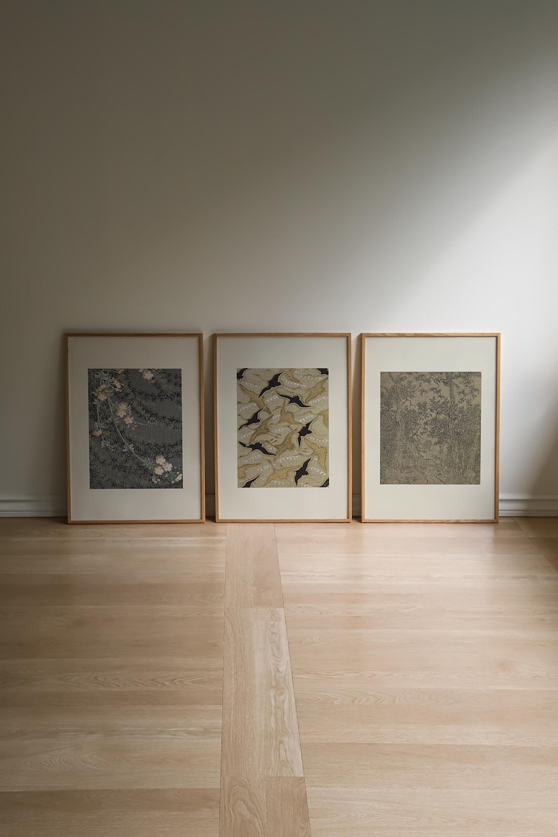 Neutral Japandi wall art set of 3 featuring delicate floral motifs, organic leaf patterns and intricate vintage inspired artwork in sage green, taupe, cream and black, framed in natural wood for wabi sabi and Scandinavian interiors.