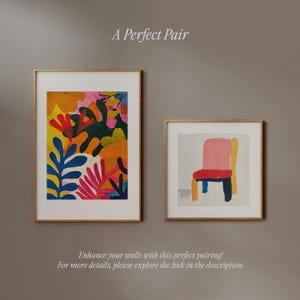 May include: Two framed art prints, one with a colorful abstract floral design and the other with a simple pink chair on a white background. The text "A Perfect Pair" is above the prints.