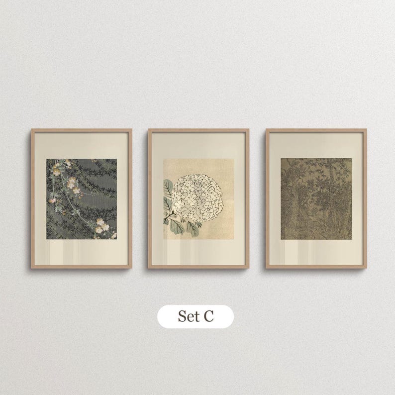 Earth tone gallery wall set of three combining a dark floral print, a brown abstract nature pattern with small blue accents and a vintage woodland drawing. Arranged in minimalist wooden frames with warm ivory borders, these muted botanical artworks complement mid century modern decor, retro-inspired living rooms and sophisticated neutral interiors.