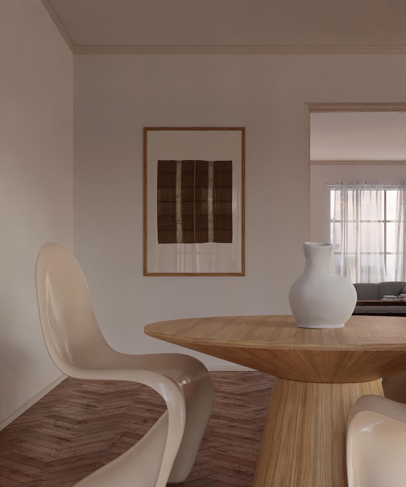 Framed brown checker pattern textile print styled above a wooden dining table in a neutral organic modern dining room with Japandi decor.