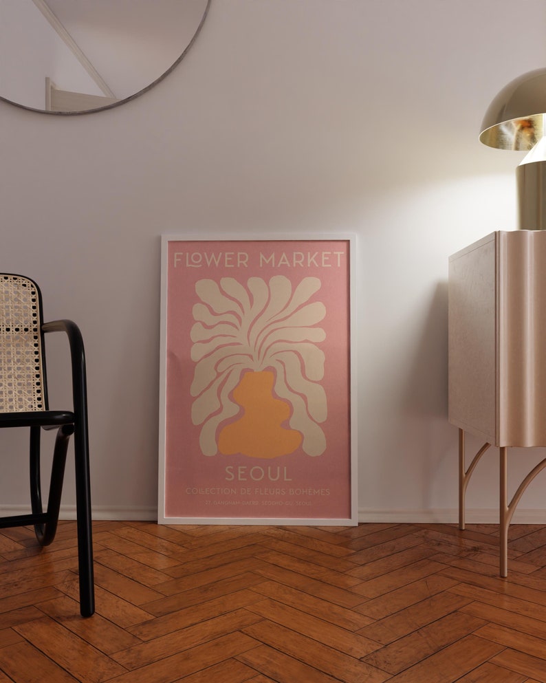 May include: A pink and white poster with the text "FLOWER MARKET" and "SEOUL" in a white frame. The poster features a stylized illustration of a flower in a vase.