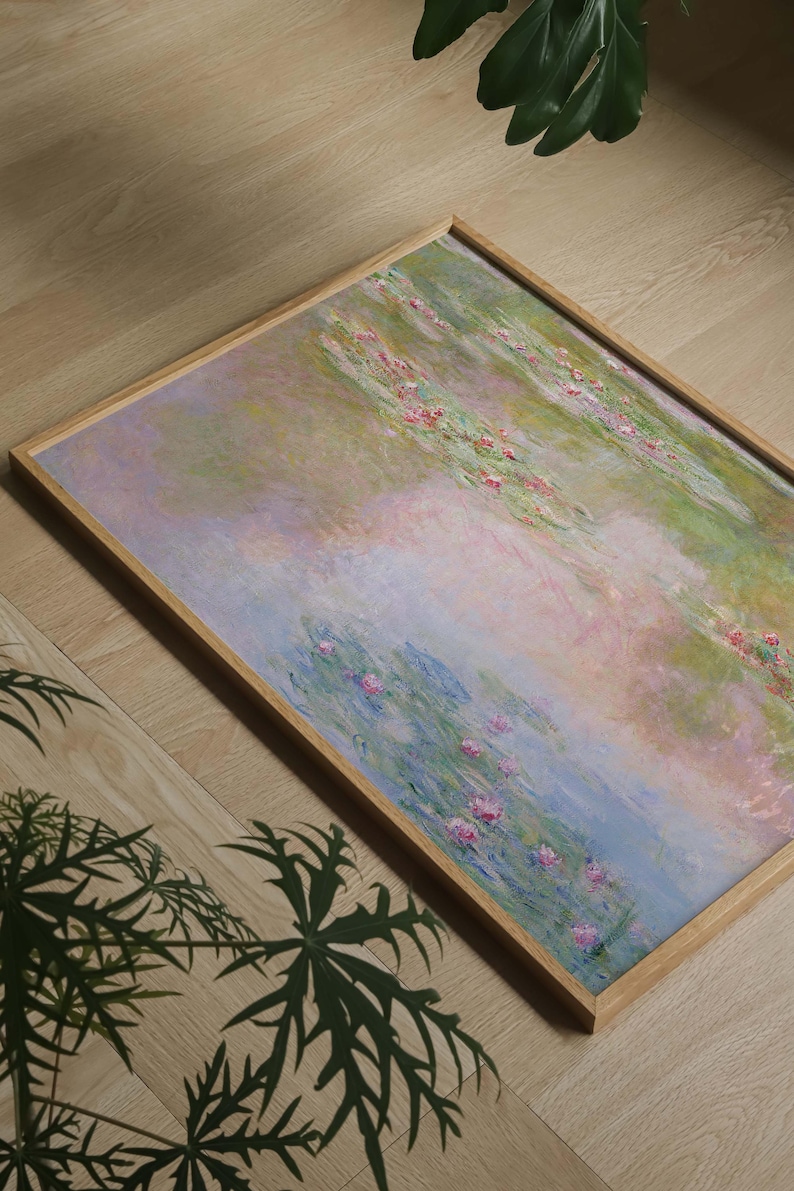Puede incluir: Una pieza de arte mural rectangular enmarcada que presenta una pintura de estilo impresionista de un estanque con nen&uacute;fares. La obra muestra tonos suaves de azul claro, rosa p&aacute;lido y verde, dentro de un marco de madera de tono claro.