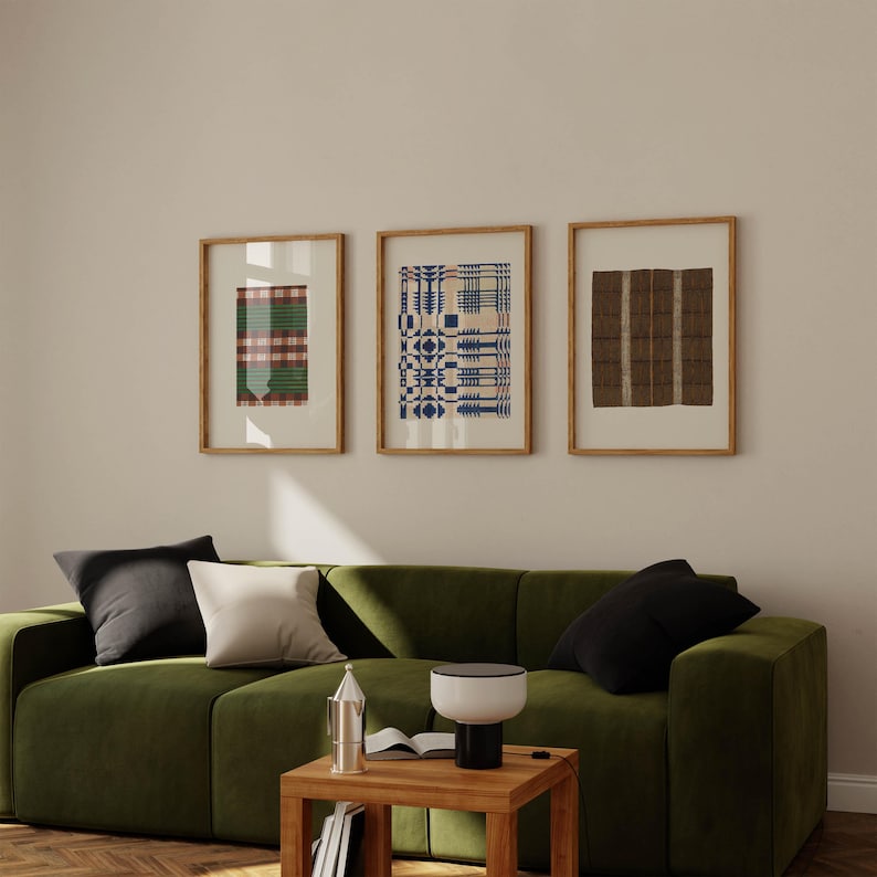 Pu&ograve; includere: Tre stampe artistiche rettangolari incorniciate con cornici in legno chiaro. La stampa a sinistra presenta un motivo a quadri verde e rosso. Quella centrale mostra un design a griglia geometrica blu e crema. Quella a destra ha strisce verticali marroni.