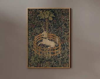 May include: A framed tapestry depicts a white unicorn within a wooden fence, surrounded by a lush, detailed forest. The artwork features a gold frame and a rich color palette of greens, reds, and browns, creating a vintage aesthetic.