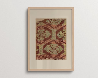 May include: A framed wall art piece featuring a rectangular textile fragment with a repeating geometric pattern in shades of deep red and muted yellow-green. The fabric has frayed edges and is centered within a light-colored mat and a wooden frame.