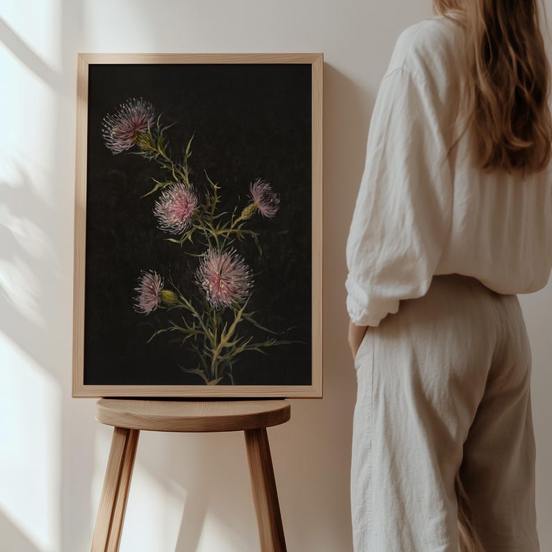May include: A framed print of a botanical illustration featuring a cluster of pink thistle flowers on a black background.