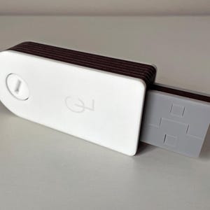 May include: A white and brown USB flash drive with a gray connector. The device has a rounded shape with a button and a logo on the white surface. The edges are brown.