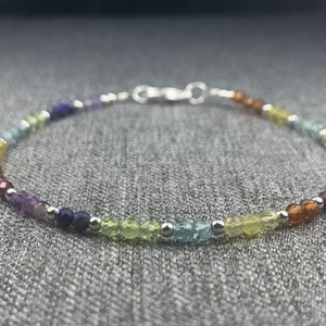 May include: A rainbow gemstone bracelet with silver beads and a silver clasp.
