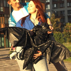 Mochila de cuero de bebé dragón con alas transformables y aliento de niebla