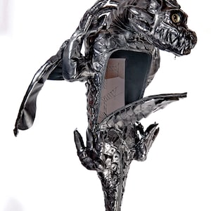 May include: A metallic dragon sculpture with open compartment. The dragon is silver with intricate details, including scales, wings, and claws. The sculpture has a menacing expression and is set against a white background.