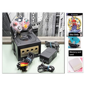 May include: A black Nintendo GameCube console with a clear red and black controller, a memory card, and a copy of Super Mario Sunshine. The console is connected to a power adapter and AV cables. The game is in its original case and includes the game disc.  Disc Only. Memory card used.
