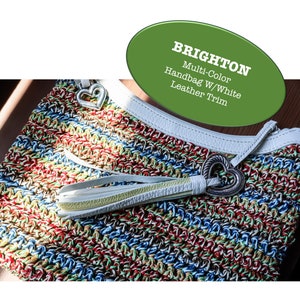 May include: Multi-color crochet handbag with white leather trim and a heart-shaped metal clasp. Brighton.