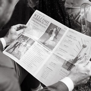May include: A black and white photo of a person reading a newspaper with the headline "Welcome to Rhode Island: A Note from the Couple." The newspaper also includes details about the bride and groom, the wedding party, and the reception.