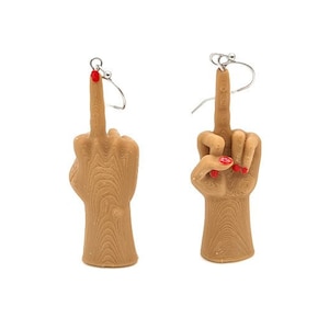 May include: A pair of earrings featuring a middle finger hand gesture with red nail polish. The earrings are made of a brown material and have silver hooks.