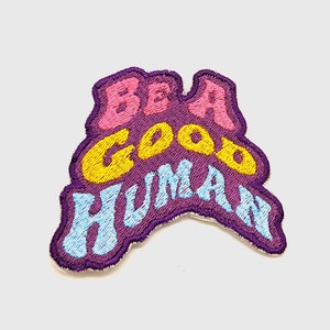 May include: Purple embroidered patch with the text "Be a Good Human" in pink, yellow, and blue lettering.