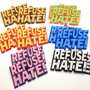 Kolczyki Refuse Hate Statement, w wielu kombinacjach kolorystycznych, z haczykami ze stali nierdzewnej lub 14-karatowego złota, drukowane w technologii 3D