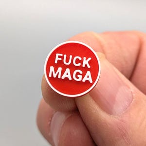 Pin pequeño de solapa con la inscripción "FUCK MAGA", impreso en 3D con plástico PLA rojo y blanco.