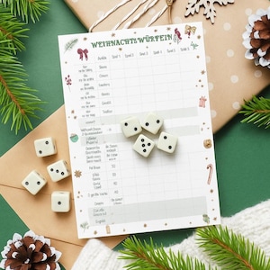 以下が含まれることがあります： 「WEIHNACHTSWÜRFEIN」のドイツ語のテキストとイラストが描かれた白いゲームシート。黒い点のある6つの白いサイコロがシートの近くに配置されています。シートは、松の葉と松ぼっくりがある茶色の表面にあります。