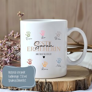 May include: White ceramic mug with a handle, decorated with colorful handprints and the text "BESTE ERZIEHERIN Sarah". The mug also includes the text "DANKE F&Uuml;R DIE TOLLE KITA ZEIT". The mug has a capacity of 330 ml.