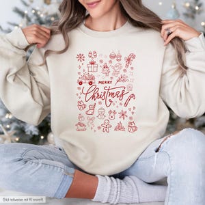 Könnte beinhalten: Ein cremefarbenes Sweatshirt mit Rundhalsausschnitt und einem roten Grafikdruck des Textes Merry Christmas, umgeben von verschiedenen Weihnachtssymbolen wie einem Lastwagen, dem Weihnachtsmann, einem Schneemann, einem Lebkuchenmann und Schneeflocken.