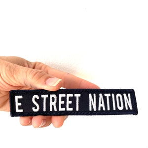 May include: Black fabric patch with white text that reads "E STREET NATION".
