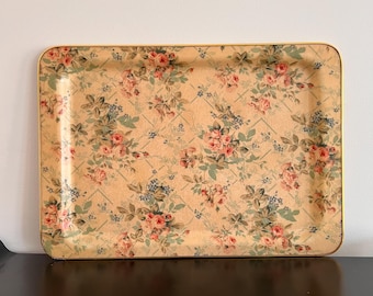 May include: A rectangular tray with a gold trim and a floral pattern. The pattern features pink and white roses with green leaves on a beige background.