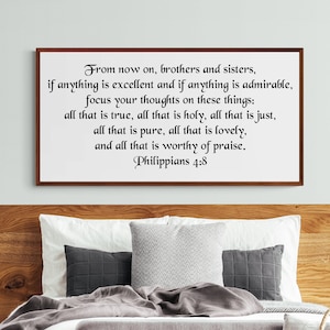 May include: A framed print with a wood frame and a white background. The print features a black and white text quote from Philippians 4:8, which reads: "From now on, brothers and sisters, if anything is excellent and if anything is admirable, focus your thoughts on these things: all that is true, all that is holy, all that is just, all that is pure, all that is lovely, and all that is worthy of praise."
