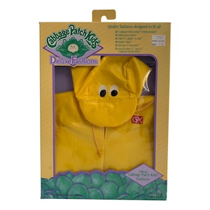 May include: A yellow raincoat with a matching yellow hat and a red Cabbage Patch Kids logo. The packaging says "Deluxe Fashions" and "Official Cabbage Patch Kids Fashions".
