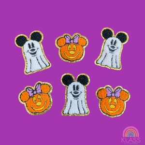 May include: Six Halloween-themed patches featuring cartoon characters. The patches include Mickey Mouse as a ghost and Minnie Mouse as a jack-o'-lantern. Each patch has a gold glitter border and is set against a purple background.