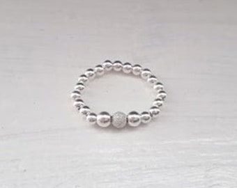 Sterling silver beaded stretch elastic ring with shimmer stardust sterling silver bead.