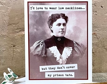 May include: A vintage-style greeting card with a black and white photo of a woman wearing a patterned dress. The text on the card reads "I'd love to wear low necklines... but they don't cover my prison tats."