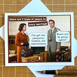May include: A rectangular greeting card featuring a scene of a woman in an orange suit and a man in a tweed suit with luggage. Text reads: There are 2 types of people in every marriage. Speech bubbles say: I've got the passports, tickets, and reservations. Where are we going again?