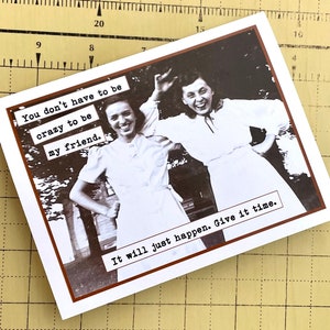 May include: A vintage-style greeting card with a black and white photo of two women smiling. The text on the card reads "You don't have to be crazy to be my friend. It will just happen. Give it time."
