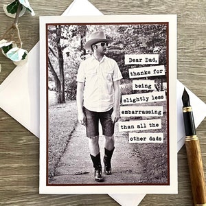 May include: A black and white photo of a man wearing a cowboy hat and sunglasses. The photo is on a card with the text "Dear Dad, thanks for being slightly less embarrassing than all the other dads".