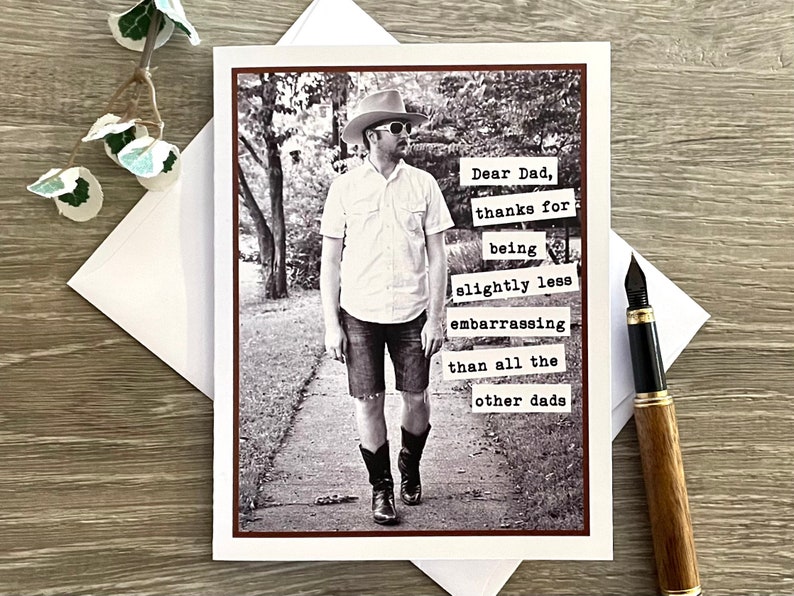 May include: A black and white photo of a man wearing a cowboy hat and sunglasses. The photo is on a card with the text "Dear Dad, thanks for being slightly less embarrassing than all the other dads".