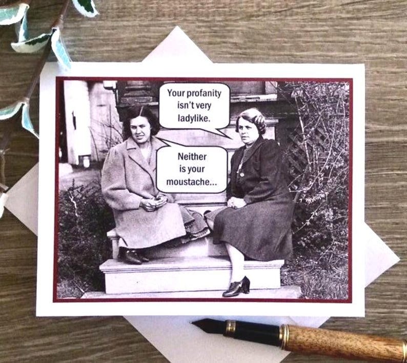 May include: A humorous greeting card with a black and white photo of two women. The card features the text "Your profanity isn't very ladylike. Neither is your moustache..."