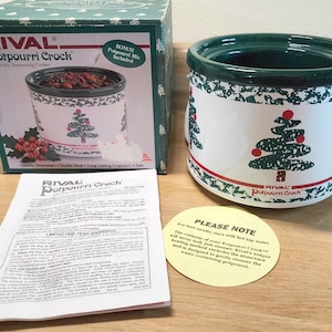 Peut inclure: Un pot-pourri Rival blanc avec un bord vert et un motif de sapin de Noël. La boîte et les instructions sont incluses. Le pot est une mijoteuse électrique pour pot-pourri.