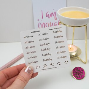 May include: A sheet of white sticker paper with the word "birthday" repeated 18 times in a gold font. The sticker sheet is labeled "BIRTHDAY sticker sheet SC-14".