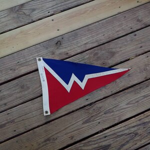 Op de afbeelding: Een rode, witte en blauwe driehoekige vlag met een wit zigzagontwerp. De vlag is gemaakt van stof en heeft een witte rand. De tekst "101071" is op de vlag gedrukt.