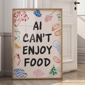 Op de afbeelding: Een ingelijste kunstprint met de tekst "AI CAN'T ENJOY FOOD" in zwart, omringd door kleurrijke voedselillustraties. Het kunstwerk bevat tekeningen van pizza, pasta, ijs en andere voedingsmiddelen. De lijst is van lichtgekleurd hout.