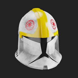 May include: A white and yellow clone trooper helmet with a red star symbol on the side. The helmet has a weathered, battle-worn look.