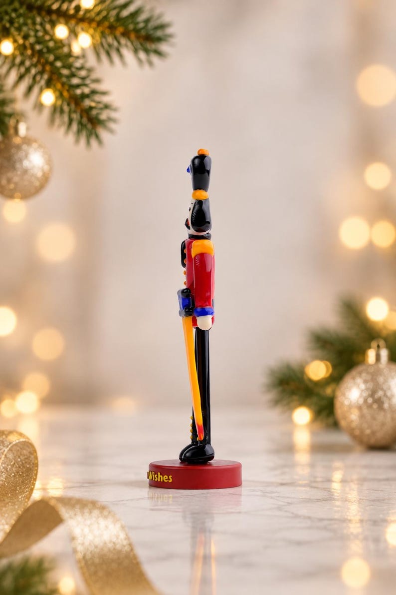 Close-up of the personalized 3D-printed base paired with the handmade glass Nutcracker, showing the raised yellow Christmas Wishes lettering.