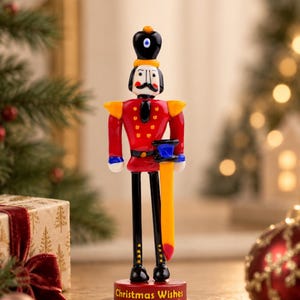 Tabletop Christmas decor featuring a colorful handmade glass Nutcracker soldier on its matching red display stand.