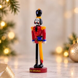Small 5.5-inch glass Nutcracker figurine shown in a styled Christmas setting to demonstrate its tabletop display scale.