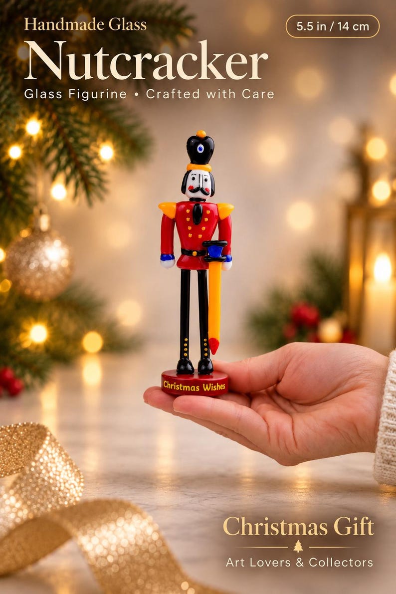 Front view of a colorful lampworked glass Nutcracker soldier with a black hat, red uniform, black boots, and a red display base.
